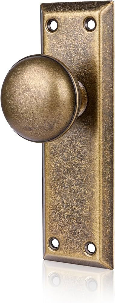 Bouton de porte vintage en laiton vieilli sur plaque rectangulaire pour restaurant.