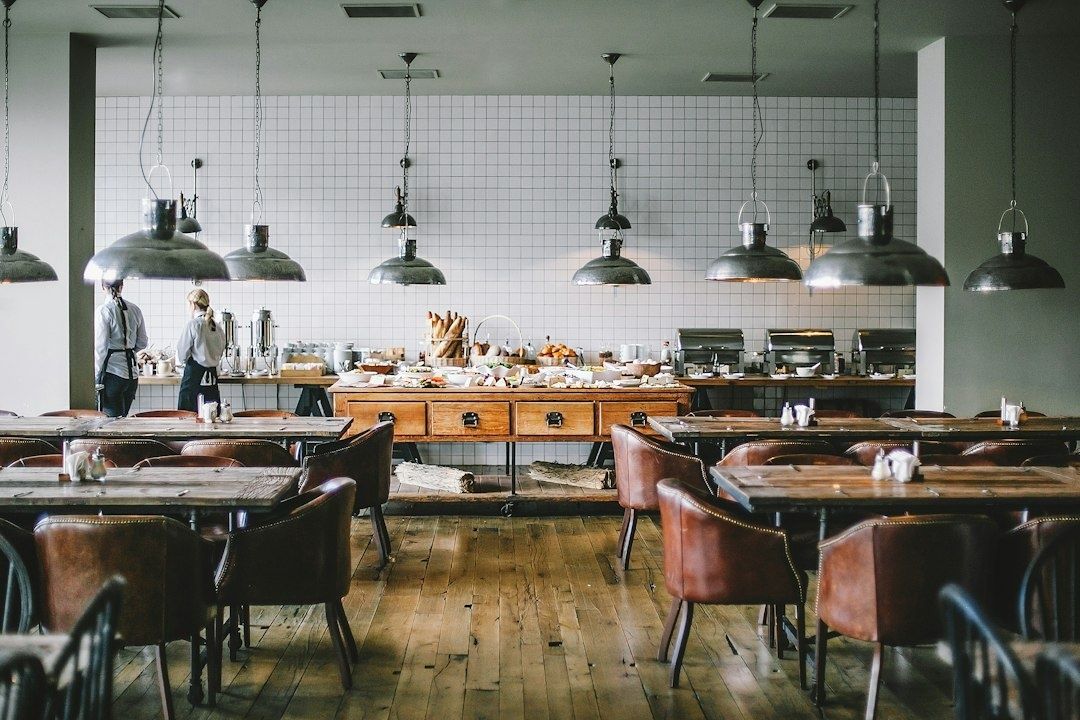 Salle de restaurant éclairée par de grandes suspensions métalliques